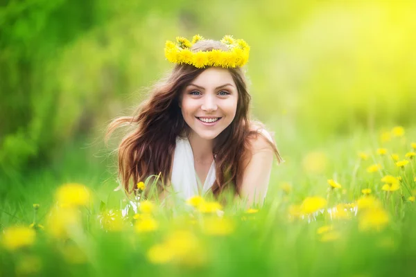 Dandelions sahada, mutlu che uzanmış güzel bir kadın görüntüsü — Stok fotoğraf