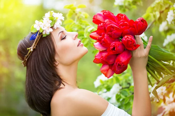 Porträt einer schönen jungen Frau in einem Kranz aus Frühlingsblumen — Stockfoto