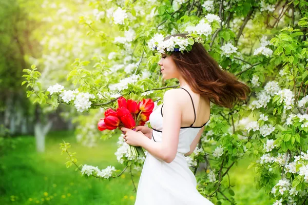 Ritratto di una bella giovane donna in una corona di fiori primaverili — Foto Stock