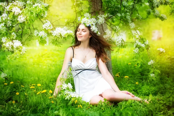 รูปภาพของหญิงสาวที่สวยงาม ในดอกไม้ฤดูใบไม้ผลิ — ภาพถ่ายสต็อก
