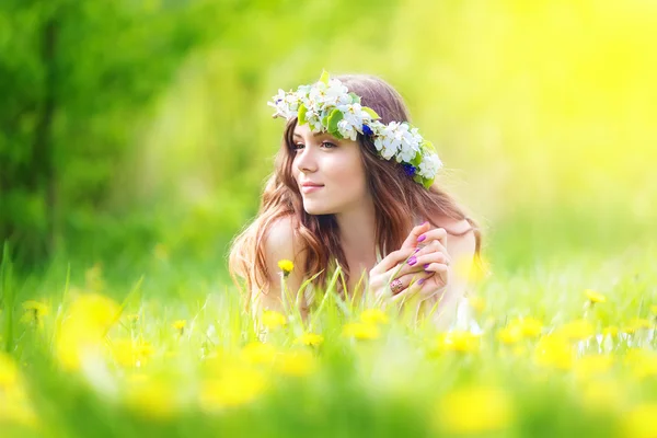 Dandelions sahada, mutlu che uzanmış güzel bir kadın görüntüsü — Stok fotoğraf