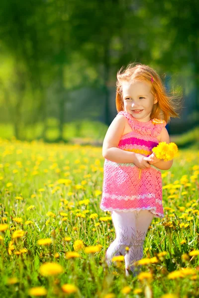 Image of happy child on dandelions field, cheerful little girl r — Stock Photo, Image