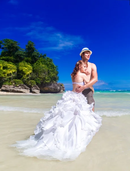Happy bride and groom hug on the beach on the tropical island. — Stock Photo, Image
