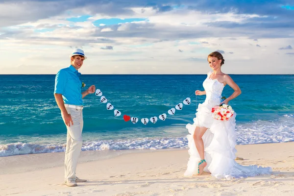 Happy bride and groom having fun on a tropical beach. Just marri — Stock Photo, Image