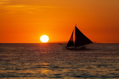 tropikal deniz üstünde yelkenli günbatımında. siluet fotoğraf.