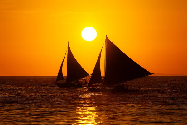 Segelboote bei Sonnenuntergang auf einem tropischen Meer. Silhouettenfoto. — Stockfoto