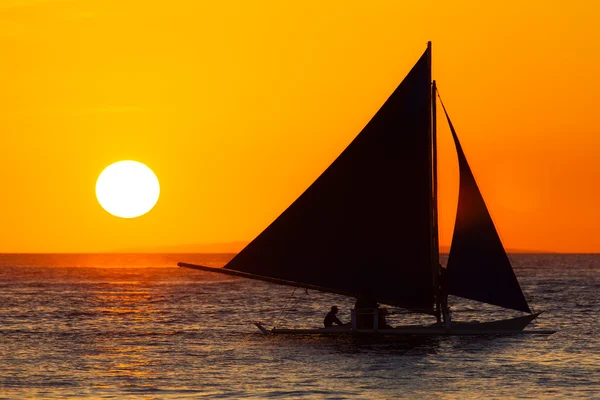 Segelboot bei Sonnenuntergang auf einem tropischen Meer. Silhouettenfoto. — Stockfoto