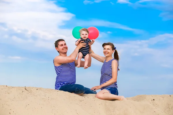 Familia feliz, mamá, papá e hijo pequeño en chalecos a rayas que tienen fu —  Fotos de Stock