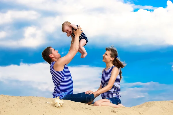 Familia feliz, mamá, papá e hijo pequeño en chalecos a rayas que tienen fu — Foto de Stock