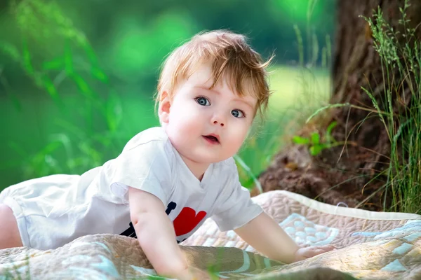 Happy little baby having fun in the park on the lake shore backg — Stock Photo, Image