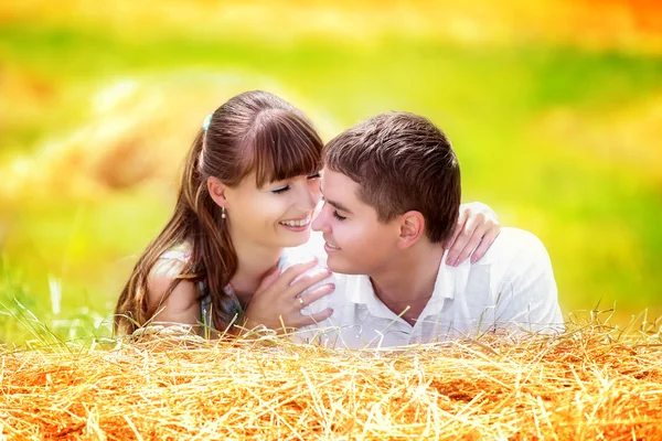 Amar a la feliz pareja divirtiéndose en un campo en un pajar. Verano —  Fotos de Stock