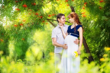 mutlu ve genç hamile iki parkta sarılma. Yaz vaca