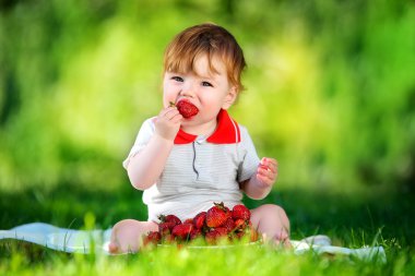 mutlu bebek strawberr ile güneşli bir çayır üzerinde park eğlence var