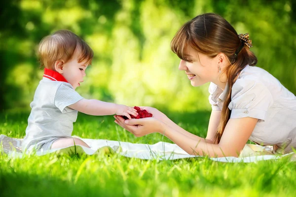 Familia feliz, mamá e hijo pequeño divirtiéndose en el parque. Raspber. — Foto de Stock