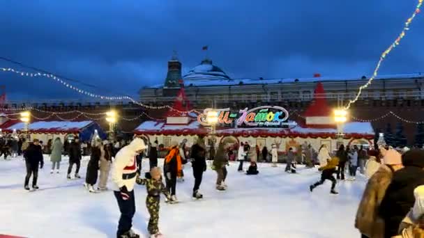 Schlittschuhlaufen auf der Eisbahn auf dem Neujahrsmarkt auf dem Roten Platz Moskau, Russland, 19. Dezember 2021 — Stockvideo