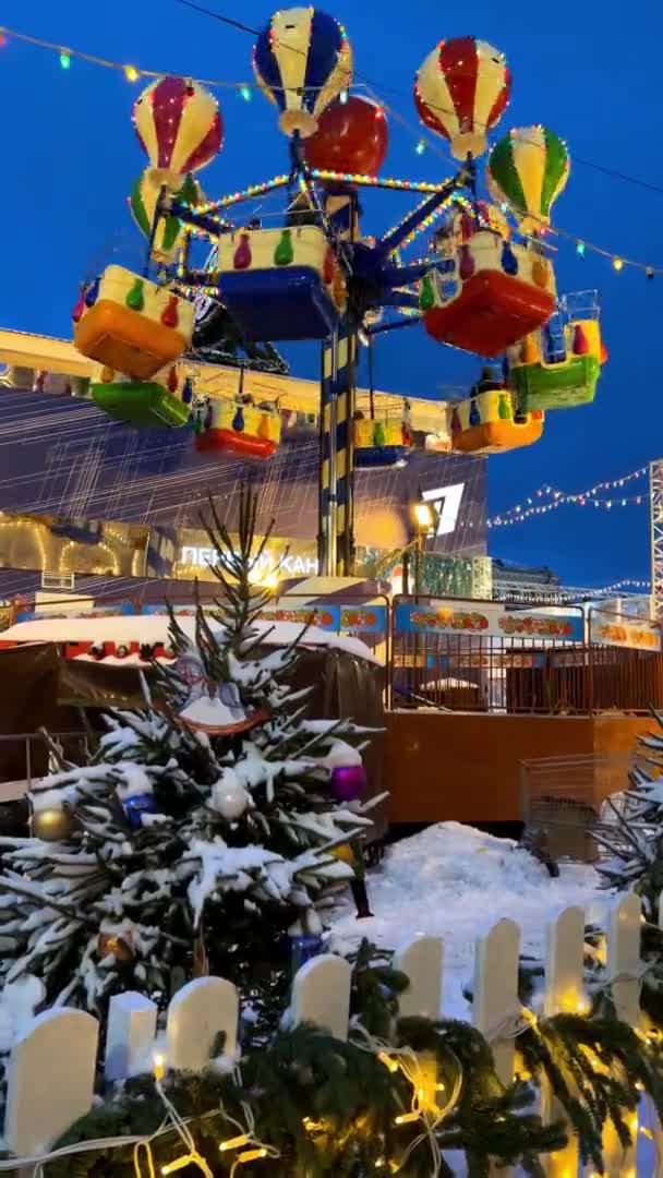 Red Square Nightのクリスマスフェアでの新年のカルーセル冬の雪モスクワ ロシア 12月19 2021垂直ビデオ 高品質4K映像 — ストック動画