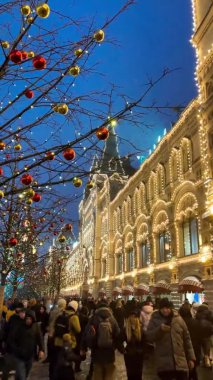 Yeni yıl ve Noel için sokak dekore edildi. Gece kar yağışlı Moskova, Rusya, 19 Aralık 2021 Dikey video formatı Yüksek kaliteli 4K görüntü