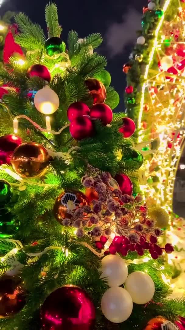 Weihnachtsbaum auf der Straße geschmückt für Neujahr. Vertikales Video Nacht Winter Schnee Moskau, Russland, 19. Dezember 2021 — Stockvideo