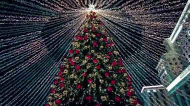 Yılbaşı için sokakta süslenmiş Noel ağacı. 19 Aralık 2021 'de Moskova, Rusya' da gece karı yağdı. Yüksek kalite 4k görüntü