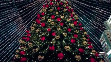 Yılbaşı için sokakta süslenmiş Noel ağacı. 19 Aralık 2021 'de Moskova, Rusya' da gece karı yağdı. Yüksek kalite 4k görüntü