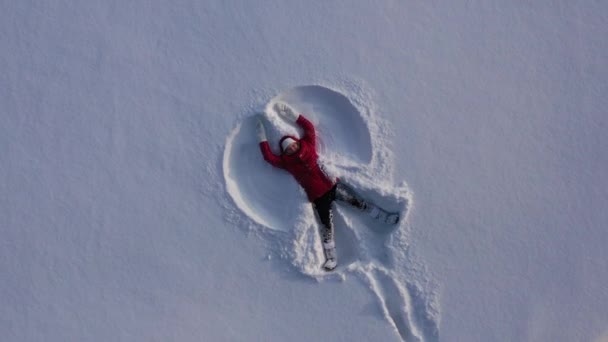 Вид Воздуха Беспилотника Девушки Красном Зимнем Пальто Делающего Снежного Ангела — стоковое видео