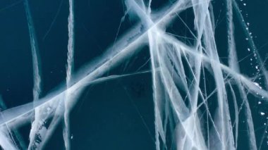 Donmuş Baykal Gölü 'ndeki İHA' dan hava görüntüsü. Mavi şeffaf buz, derin çatlaklar üst görüş. Buzun doğal soğuk arka planı. Kış soyut arkaplanı.