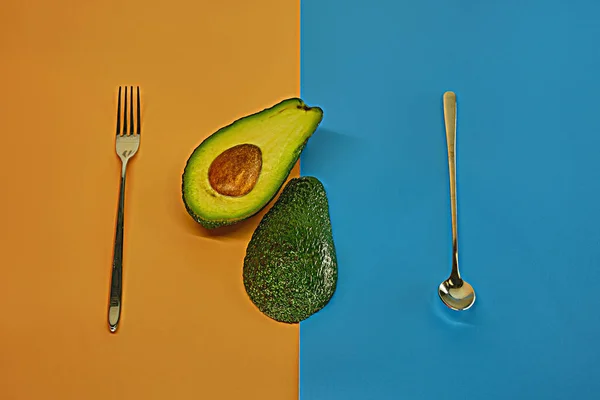 Bestek Avocado Tweeën Gesneden Een Pastelachtergrond — Stockfoto