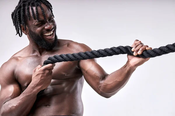 Guapo barbudo afro deportista gritando y tirando de la cuerda aislado en blanco — Foto de Stock