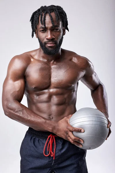 Joven fuerte sudoroso enfocado ajuste muscular hombre con grandes músculos con bola de la medicina — Foto de Stock