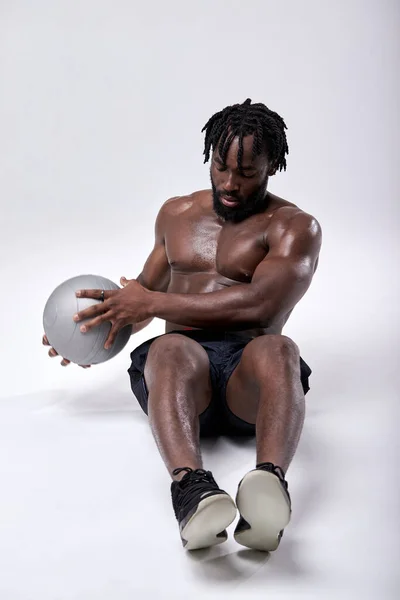 Молодий спортсмен тренується з хрестоподібним м'ячем ізольовано на білому фоні студії — стокове фото