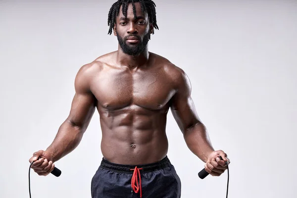 Retrato de homem africano suado sem camisa segurando pulando corda nas mãos, preparando-se para pular — Fotografia de Stock