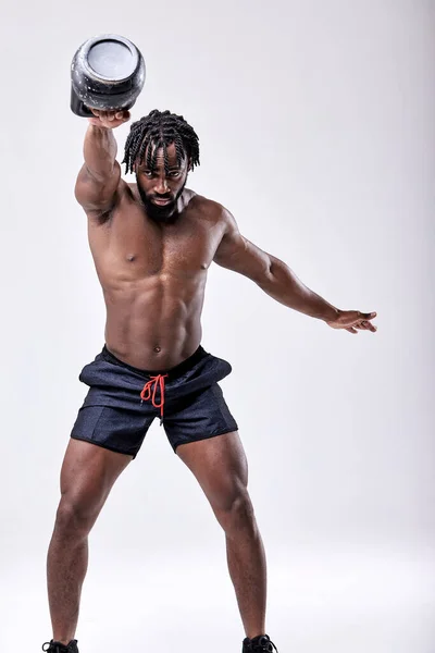 Kereszt edzés. Afro ametikán Fitness férfi csinál súlyzós edzés emelésével kettlebell — Stock Fotó