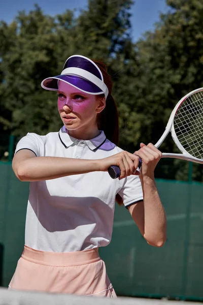 Concentrat pe joc. încrezător tânără femeie care deține rachetă de tenis și se uită departe — Fotografie, imagine de stoc