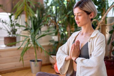Zeminde oturan sağlıklı bir kadın yoga yapıyor. Gündüz meditasyon egzersizi
