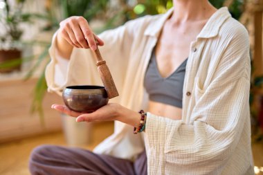 Evde tek başına oturan, müzik terapisinde şarkı söyleyen bir kadın.