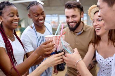 Arka bahçede, barbekü partisinde limonatayla tezahürat eden mutlu arkadaşlar.
