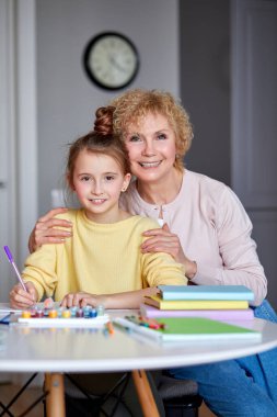 Olgun bir kadının kızıyla vakit geçirip ödev çizdiği portresi.