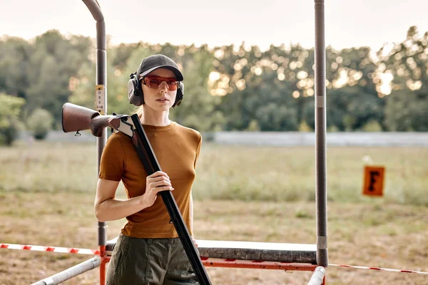 Portrait of young caucasian lady in cap after shooting practice on outdoor range — Stock Photo, Image