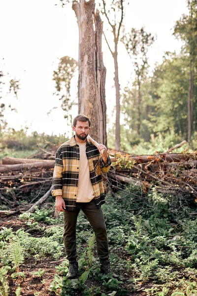 Homem de madeira confiante trabalha na floresta de verão. Lumberjack com um machado à noite. — Fotografia de Stock