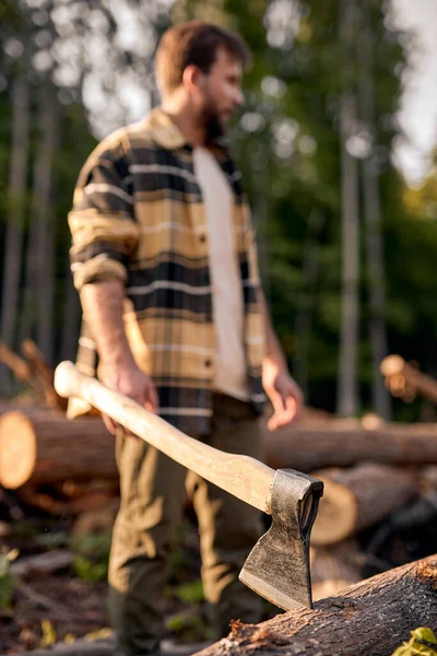 Detail of axe. Axe and firewood. Sharp ax standing on a wooden, man in the background. — Stock Photo, Image