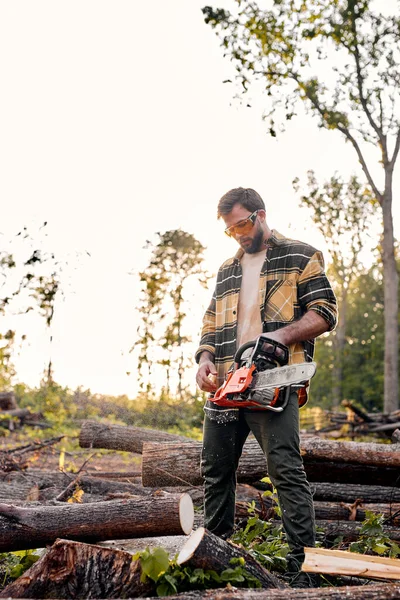 Woodman work with chainsaw in forest. Young lumberjack with chainsaw — Stock Photo, Image