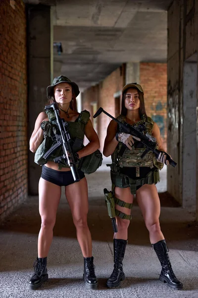 Två kvinnor soldater i redskap Ammunition Posing vid kameran med vapen — Stockfoto