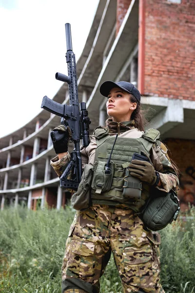 Jovem senhora militar confiante com arma na floresta, feminino em terno de camuflagem — Fotografia de Stock