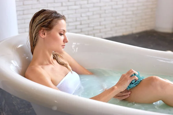 피부 관리 개념. 비누 거품 물에 누워 목욕을 하고 있는 젊은 성인 암컷 — 스톡 사진