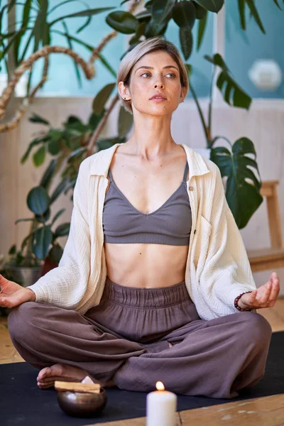 Donna sicura di sé che fa esercizio di yoga a casa, seduta sul pavimento. Meditazione di consapevolezza — Foto Stock