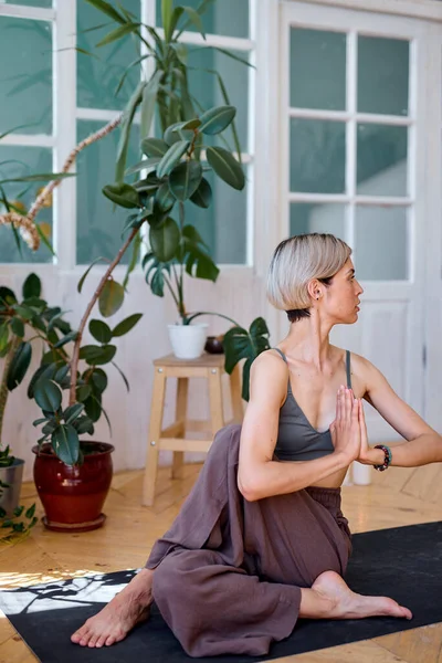 Sağlıklı bir kadın evde yoga yapıyor. Vücudunu esnetiyor. Tek başına. — Stok fotoğraf