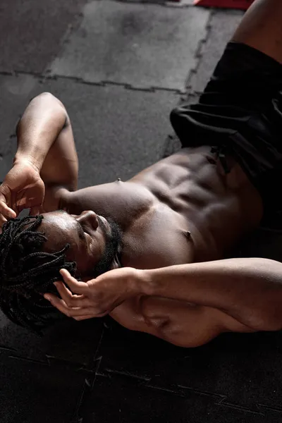 Vista superior sobre jovem negro afro-americano fazendo exercícios abdominais crunch no ginásio — Fotografia de Stock