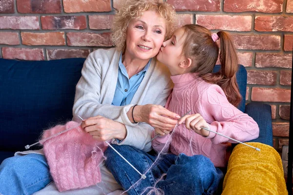 Senior mulher ensinando a menina adolescente para tricotar com agulhas, menina está beijando vovó — Fotografia de Stock