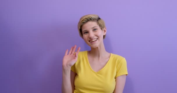 Porträtt av ung och vacker korthårig kvinna glatt leende, viftande hand — Stockvideo