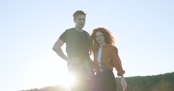 Adorable femme et l'homme se tiennent câlins dans les montagnes au coucher du soleil dans la soirée — Video